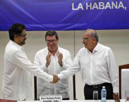 Luciano Marín, de la FARC(izquierda), saluda al delegado del Gobierno Colombiano, Humberto de la calle en presencia del canciller cubano, Bruno Rodríguez.