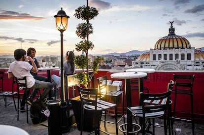 Terraza de un café en Ciudad de México, con el Palacio de Bellas Artes al fondo.