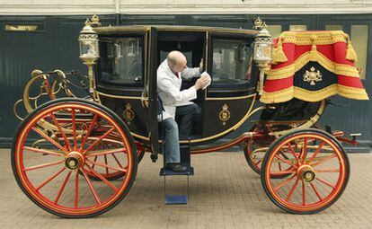 El restaurador de carruajes Dave Evans limpia la carroza landó real de 1902 en las Caballerizas Reales en el centro de Londres. Esta carroza la utilizarán el príncipe Guillermo de Inglaterra y su prometida Kate Middleton en su boda, el próximo 29 de abril, si el tiempo lo permite.