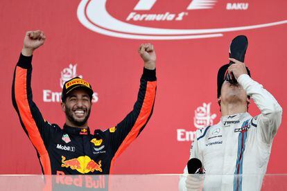 Daniel Ricciardo, ganador de la carrera, celebra su victoria levantando los brazos mientras Lance Stroll se refresca.