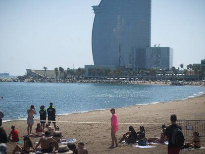 En foto, la playa de Sant Sebastià desalojada por la Guardia Urbana de Barcelona. En vídeo, los explosivos encontrados bajo el mar.