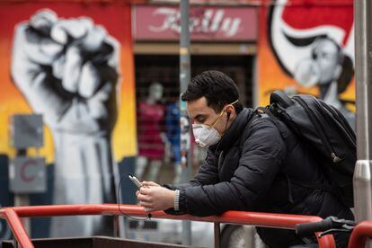 Un hombre mira la pantalla de su teléfono móvil durante la pandemia.