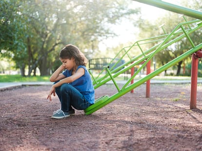 Una niña triste en un patio de recreo, en una fotografía ilustrativa.