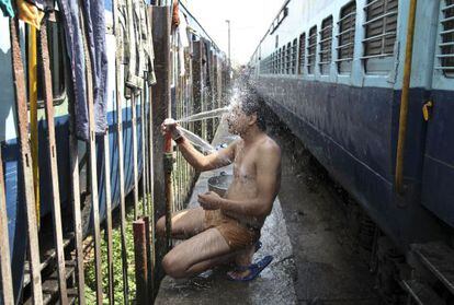 Un pasajero se baña en una estación de trenes de Jammu, India, este lunes.