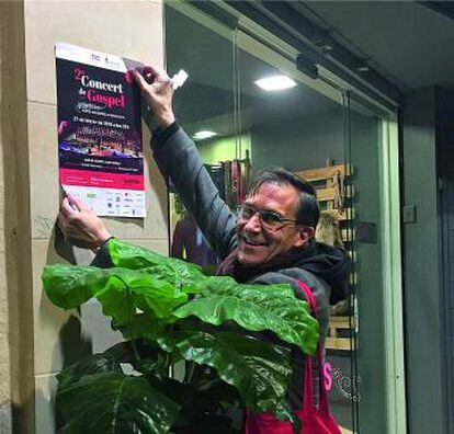 Un voluntario de la empresa pegando carteles para promocionar el concierto.