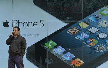 Un hombre habla frente a un cartel de Apple en Pekín