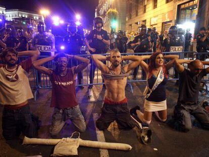 Un grupo de manifestantes se arrodilla ante la policía.