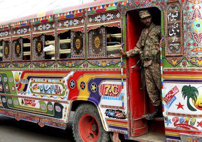 Un soldado paquistaní monta guardia en un autobús que transporta personal electoral y material, a las estaciones en Karachi. Pakistán se prepara para celebrar este miércoles elecciones, en medio de una polémca campaña, por las supuestas interferencias del ejército. 