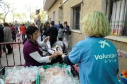 Voluntarios de La Caixa atienden a personas con pocos recursos.
