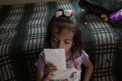 Liz, una niña de 10 años con discapacidad múltiple, observa una foto en el cuarto de azotea donde vive con su madre. Al nacer a Liz le diagnosticaron síndrome de Miller-Dieker. Pero a medida que ha ido creciendo los doctores han descartado que sufra de este síndrome Ecatepec, Estado de México.