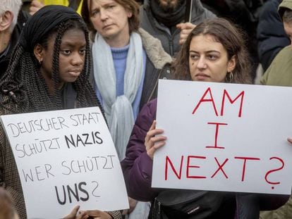Dos mujeres con carteles en protesta contra la matanza racista, el 22 de febrero en una manifestación en Hanau.