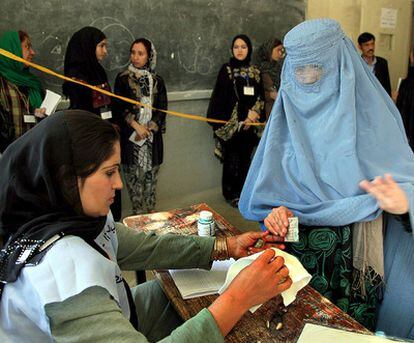 Una mujer, ataviada con un burka, vota en un centro electoral de Kabul