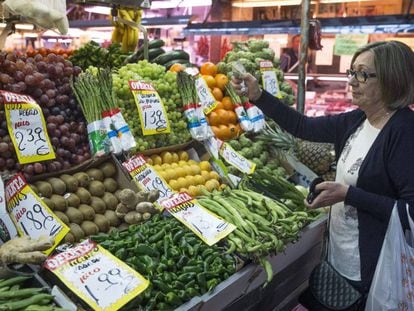 Una mujer hace su compra en una fruter&iacute;a del mercado Maravilla en Madrid