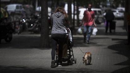 Una mujer pasea a su bebé por las calles de Barcelona.