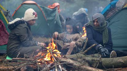 Migrants gather near a fire on the Belarusian-Polish border in the Grodno region, Belarus November 10, 2021. Ramil Nasibulin/BelTA/Handout via REUTERS ATTENTION EDITORS - THIS IMAGE HAS BEEN SUPPLIED BY A THIRD PARTY. NO RESALES. NO ARCHIVE. MANDATORY CREDIT.