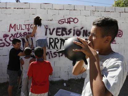 Unos j&oacute;venes pintan un grafiti en la Ca&ntilde;ada Real como parte de un programa de actividades organizadas por Cruz Roja y Obra Social La Caixa.