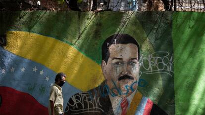 Un hombre camina frente a un mural de Maduro, en Caracas.