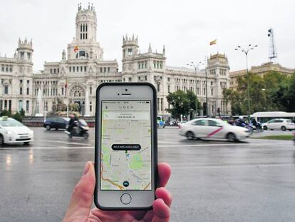 App de Uber en un teléfono móvil en la madrileña plaza de Cibeles