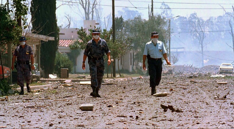 Three policemen walk down a street in Río Tercero (Argentina), after the explosion in November 1995.