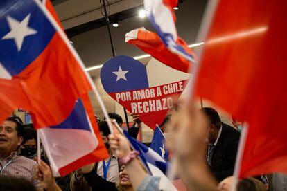 Un opositor al proyecto de Constitución sostiene un cartel con la frase Por a amor a Chile rechazo, durante las celebraciones posteriores al plebiscito.