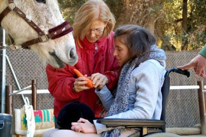 Teresa Xipell, hipoterapeuta en la Fundación Federica Cerdá, con una alumna.