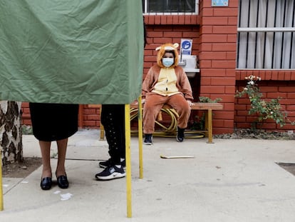 Un niño observa a su madre emitir su voto en Temuco, Chile, el pasado 17 de mayo.