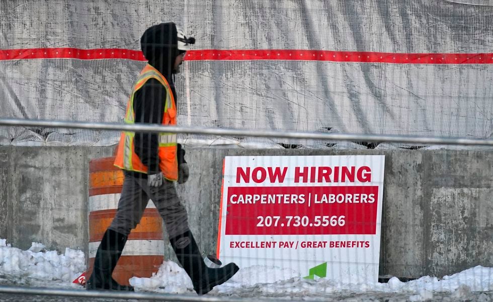 A worker passes a hiring sign at a construction site, Wednesday, Jan. 25, 2023, in Portland, Maine. On Thursday, the Labor Department reports on the number of people who applied for unemployment benefits last week. (AP Photo/Robert F. Bukaty)