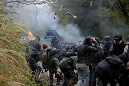 Manifestantes y policía se enfrentan durante el desalojo de un campamento de activistas en Notre Dame des Landes (Francia).
