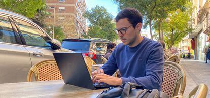 Una persona trabaja con su portátil en una terraza, en Madrid.