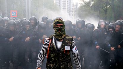 Un activista prorruso camina junto a unos policías ucranios en la ciudad de Donetsk (Ucrania).