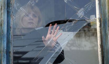 Una mujer observa los da&ntilde;os que un bombardeo ha causado en una ventana en una casa de Donetsk, el 14 de febrero.