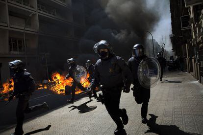 Policías corren detrás de manifestantes durante los altercados en Barcelona.