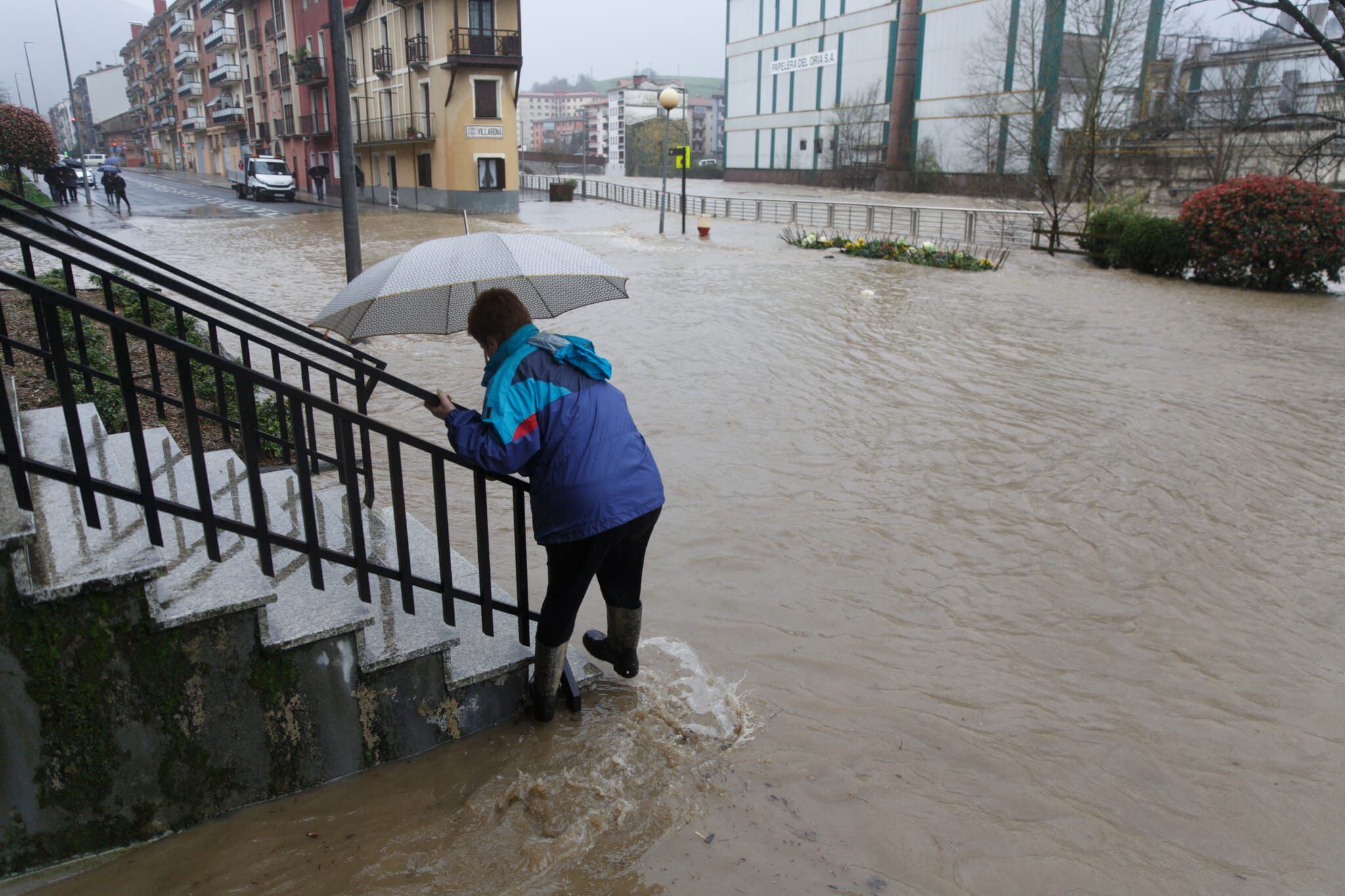 Una persona trata de sortear el agua en las inundaciones registradas este martes en Villabona (Gipuzkoa) tras desbordarse el río Oria.