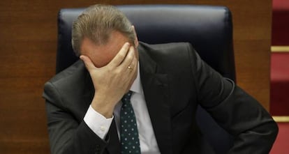 Gesto de preocupación de Alberto Fabra, sentado en su escaño de las Cortes Valencianas.