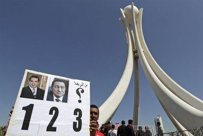 Un manifestante en Manama muestra las fotos de Ben Ali y Hosni Mubarak.