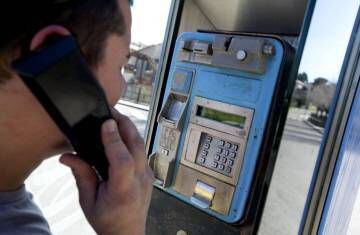Un joven utiliza una cabina telefónica.