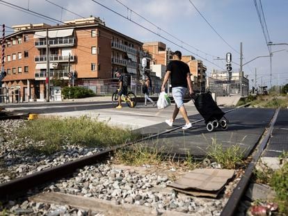 Un hombre cruza las vías de tren pese a las señales de prohibición, en Montcada.