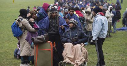 Varios refugiados esperan este jueves en la localidad alemana de Wegscheid, en la frontera con Austria.