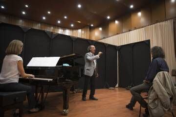 El director de orquesta Miguel Ángel Gómez Martínez da indicaciones al tenor Fabio Armiliato durante un ensayo.