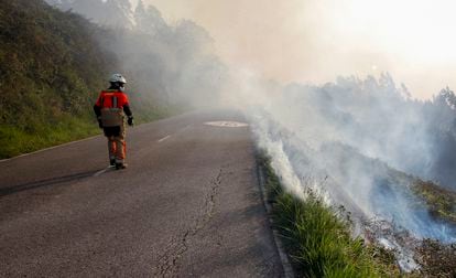 Un bombero observa la columna de humo del incendio de Monte Naranco en Oviedo, el jueves.
