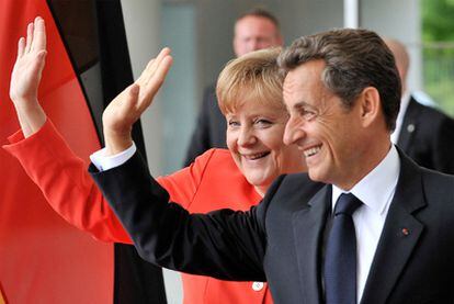 Angela Merkel junto a Nicolas Sarkozy al inicio de su encuentro ayer en Berlín.