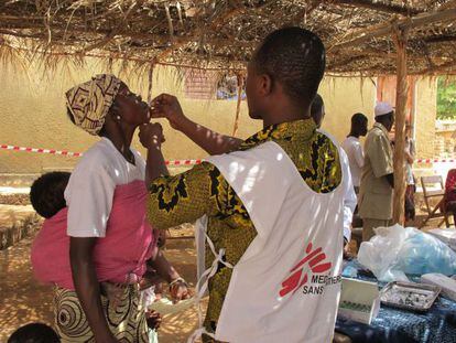 Un cooperante de Médicos sin Fronteras vacuna a una mujer en Guinea Conakry durante una epidemia de cólera.