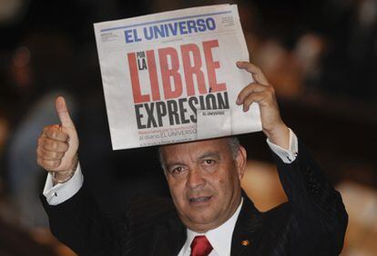 El parlamentario opositor Ramiro Teran muestra un ejemplar del diario 'El Universo' durante el discurso del presidente Correa en la Asamblea Nacional