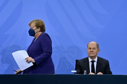 Acting Chancellor Angela Merkel arrives at the press conference to announce the new restrictions and sits next to her successor, Olaf Scholz, this Thursday in Berlin.