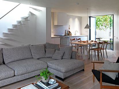 Conectados. El salón, el comedor y la cocina reciben luz de un gran ventanal y del hueco de la escalera. El sofá es de Camerich, y la mesa, un diseño de la arquitecta.