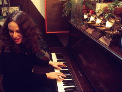 Carole King tocando el piano en casa del productor Lou Adler en marzo de 1971 en Los Angeles, ante los cuatro Grammys que acababa de ganar por 'Tapestry'.