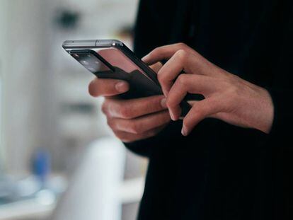 Una mujer maneja su teléfono móvil.