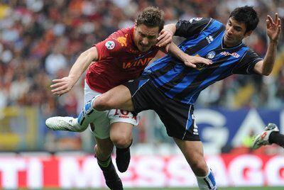Totti, frenado por Pellegrino en el partido contra el Atalanta.