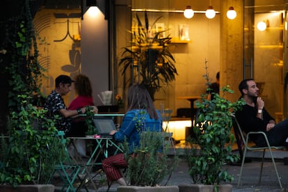 Young people, some of them foreigners, work from their laptops in a cafe in Mexico City.