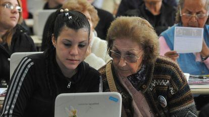 En Galicia, personas mayores aprenden a usar herramientas tecnológicas con la ayuda de jóvenes voluntarios.